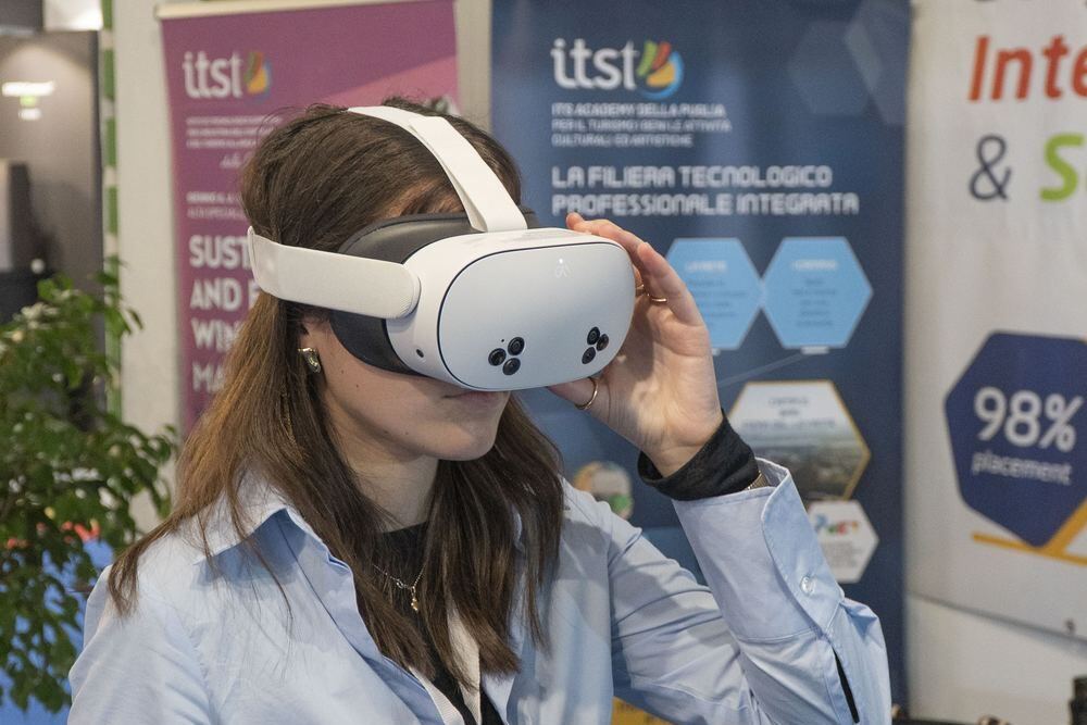 Studentessa prova un visore di realtà virtuale nello stand ITS Academy